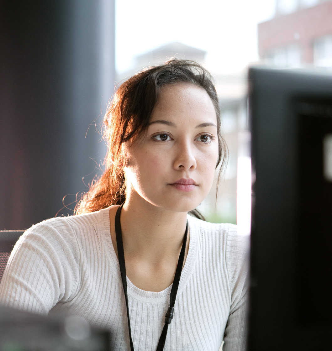 A medical coding and billing professional working at a computer monitor.